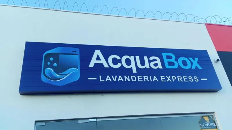 Painel em ACM azul com logo da AcquaBox Lavanderia Express