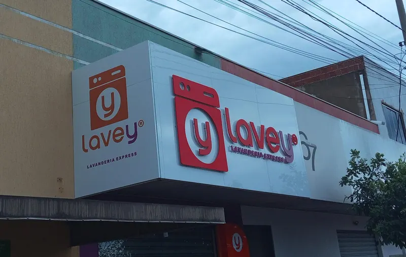 Fachada em ACM branco com letras caixa vermelhas da Lavey Lavanderia Express